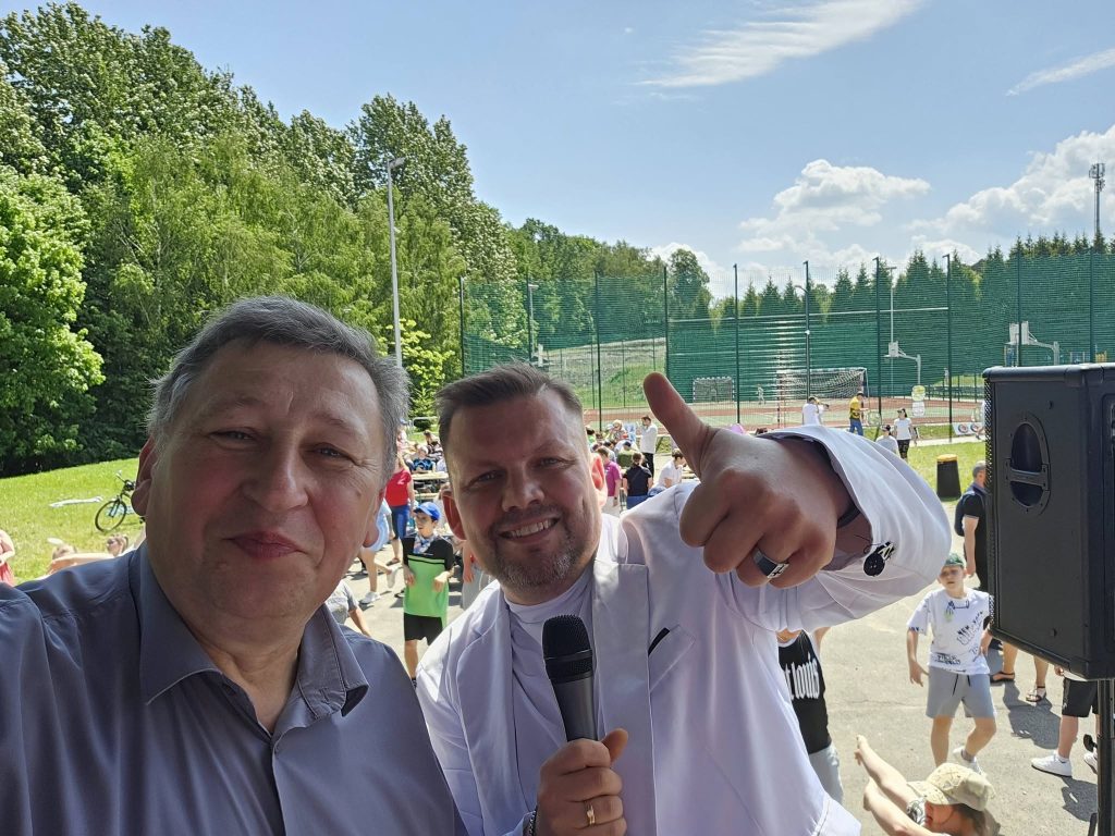 Prowadzący Dzień Dziecka z mikrofonem nagłośnienia Fundacji Zaangażowani.pl